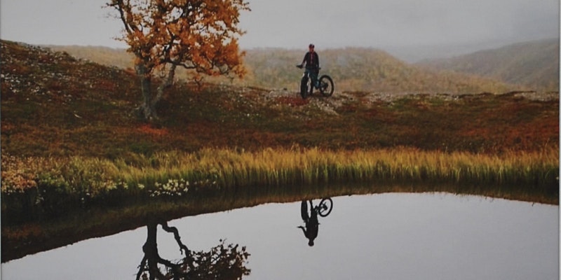 Man på cykel i naturen en höstdag