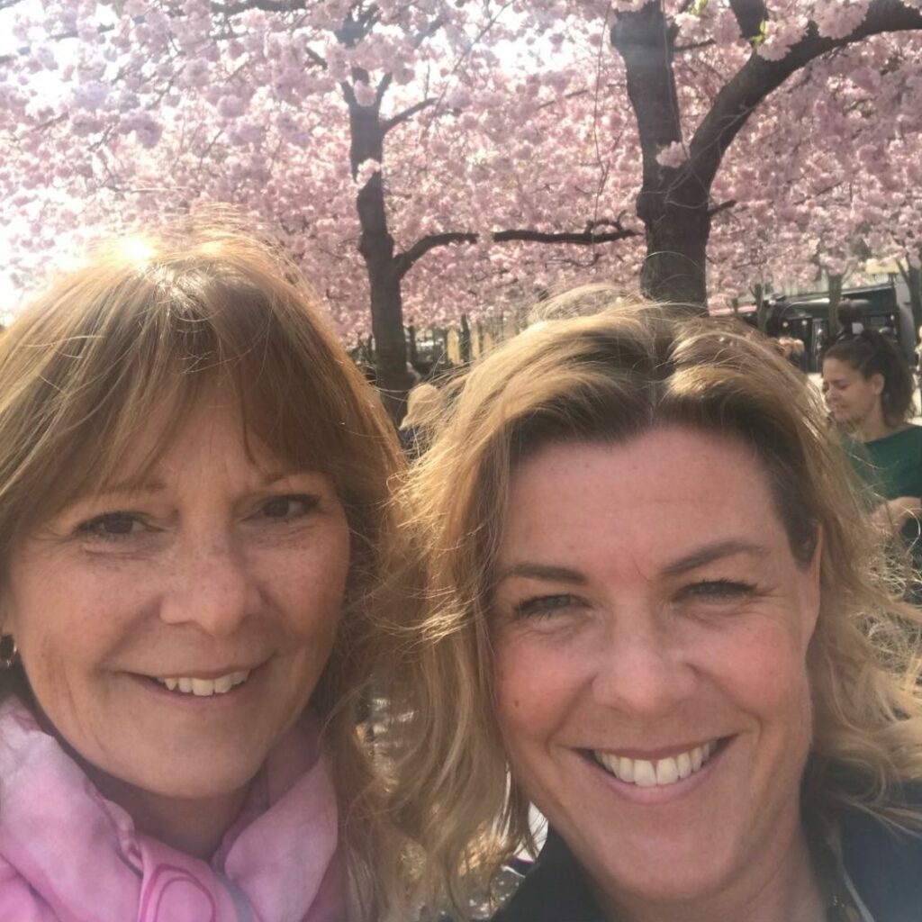 Annika och Susanna utomhua framför rosa trädbuske