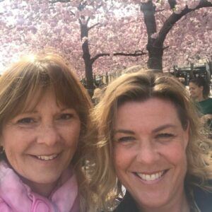 Annika och Susanna utomhua framför rosa trädbuske